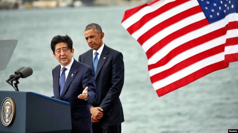 2016년 12월 26일 당시 아베 신조 일본 총리가 하와이 진주만에서 연설하고 있다. 바락 오바마 대통령이 두 손을 모으고 연설을 듣고 있다. 아베 총리는 당시 연설에서 하와이 진주만에 대한 일본의 공격으로 2400여 명의 미국인이 숨진 데 대해 애도를 표했다. 미 백악관에 따르면 아베 총리는 연설에서 전쟁의 참화를 결코 반복해서는 안된다고 말했다. /voa