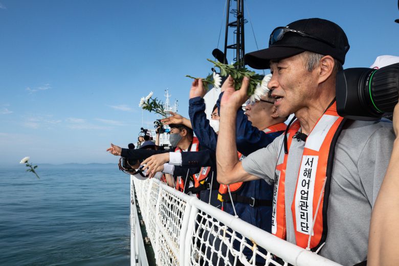 서해에서 북한군에 의해 피살된 해양수산부 공무원 이대진씨의 형 이래진 씨(오른쪽)를 바롯한 참석자들이 2022년 7월 2일 국가어업지도선 무궁화 35호에 올라 연평도 인근 사고 현장 주변 해역을 지나며 선상에서 열린 위령제에서 바다를 향해 헌화하고 있다. 2022.7.2/뉴스1