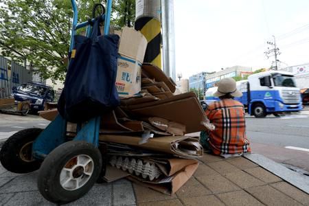 폭염이 기승을 부린 3일 오후 대구 서구 평리동에서 손수레에 폐지를 싣고 가던 노인이 가로수 아래 앉아 더위를 식히고 있다. /뉴스1