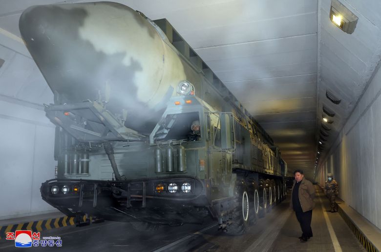 북한 김정은이 18일 기습 타격이 가능한 고체연료 기반의 대륙간탄도미사일(ICBM)인 화성-18형 옆에 서 있다. /조선중앙통신 연합뉴스