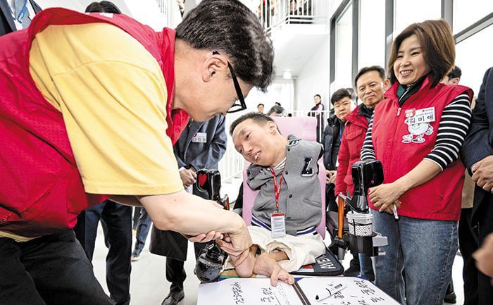 자립지원 주택 찾은 한동훈 “안녕하세요” - 국민의힘 한동훈(왼쪽) 비상대책위원장이 14일 서울 은평구 다다름하우스에서 휠체어를 탄 유태호 다다름 공간 매니저와 인사하고 있다. 다다름하우스는 성인 발달 장애 및 비장애 청년이 함께 살아가는 사회 통합형 자립 지원 주택이다. /사진공동취재단