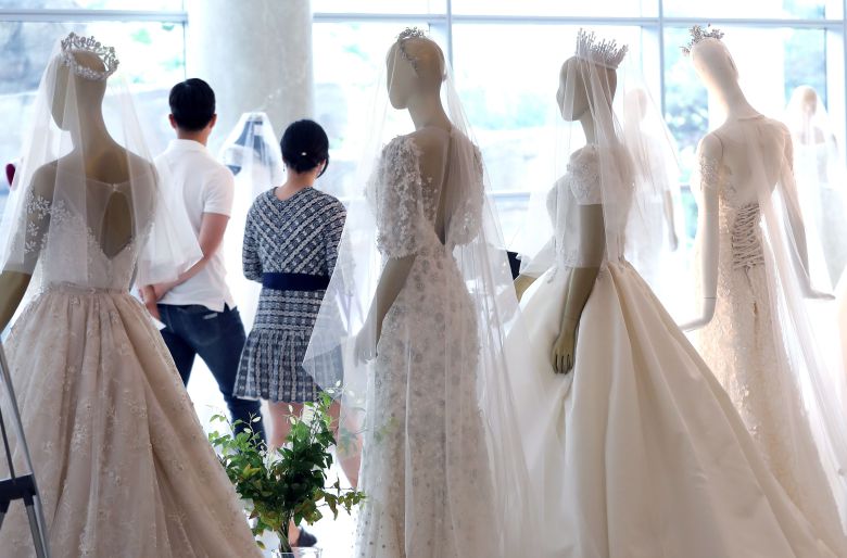2019년 서울에서 열린 한 웨딩박람회에서 예비 부부가 드레스 등 결혼 관련 상품을 둘러보고 있다. /뉴스1