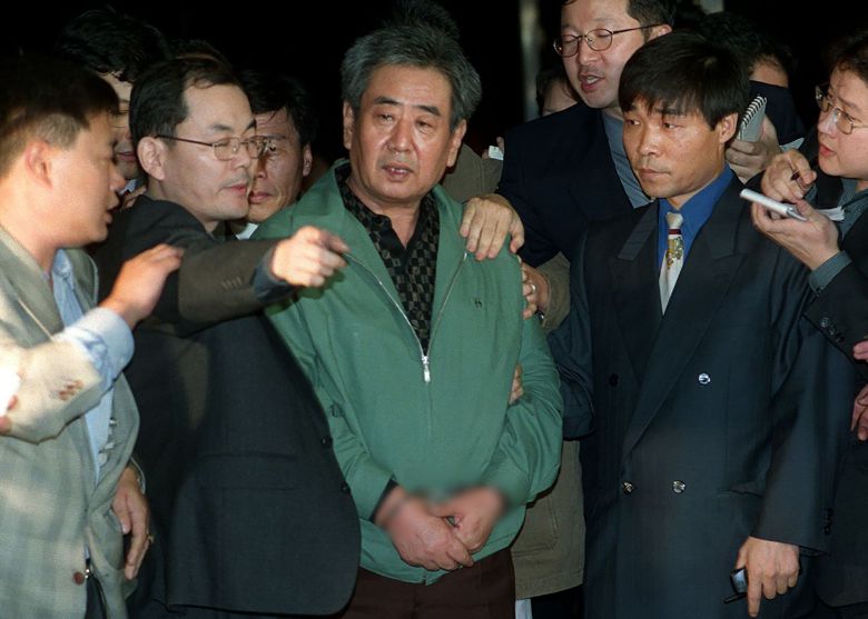 1988년 12월부터 12년간 검-경의 수배를 받아오다 자수한 '고문 경관' 이근안씨가 1999년 10월 29일 새벽 서울지검 청사로 들어서고 있다. /조선일보DB