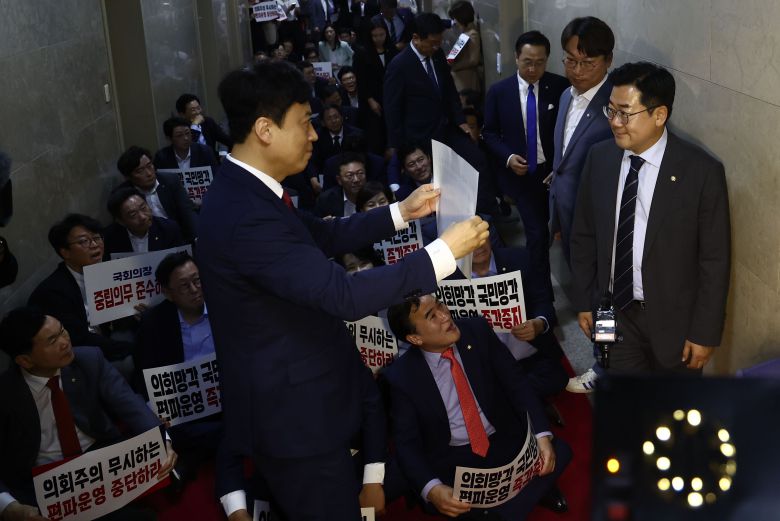 박찬대 더불어민주당 당대표 직무대행 겸 원내대표가 2일 오후 서울 여의도 국회의장실 앞에서 본회의를 앞두고 해병대원 특검법 상정에 항의하는 국민의힘 의원들 앞을 지나고 있다. /뉴스1