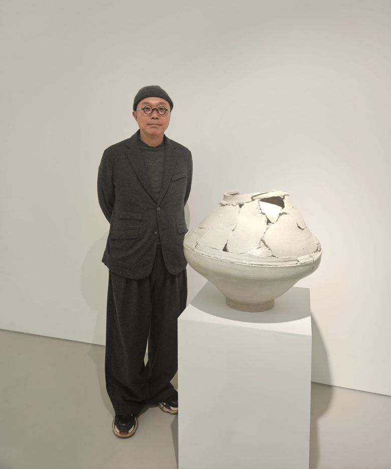 도예가 이헌정이 전시장에서 일그러진 달항아리와 함께 서 있다. /허윤희 기자