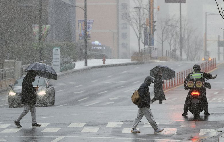 설 명절 연휴 사흘째이자 대설특보가 발효된 27일 오전 서울 성동구 거리를 지나는 우산을 쓴 시민들이 발걸음을 재촉하고 있다. /뉴스1
