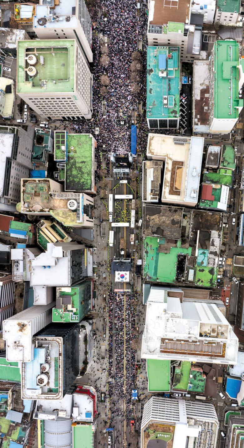 서로 다른 주장 울려퍼진 '5·18의 성지' 광주 금남로 - 15일 오후 3시 20분쯤 윤석열 대통령 탄핵 찬반 집회가 열린 광주광역시 금남로를 드론으로 촬영한 모습. 양측의 충돌을 막기 위해 경찰이 버스 4대를 'ㅁ' 자 모양으로 세워 차벽을 만들었다. 사진 위쪽이 개신교계 단체인 '세이브코리아'가 개최한 탄핵 반대 집회 현장이고, 대형 태극기 아래쪽이 광주 지역 시민·사회단체 등이 참여한 탄핵 찬성 집회 현장이다. 탄핵 반대 집회는 이날 오후 1시부터 시작해 이때가 절정이었고, 탄핵 찬성 집회는 오후 4시에 시작이어서 참가자가 다 모이지 않은 상태였다. 경찰은 탄핵 찬성 집회에 1만명, 반대 집회에는 3만명이 참가한 것으로 추산(비공식)했다. /김영근 기자