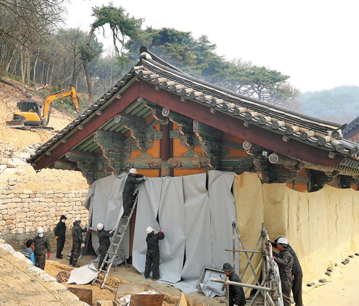 26일 경북 안동 봉정사에서 국가유산청 등 관계자들이 산불 피해를 막기 위해 국보 극락전 등 건물을 방염포로 감쌌다. /뉴스1