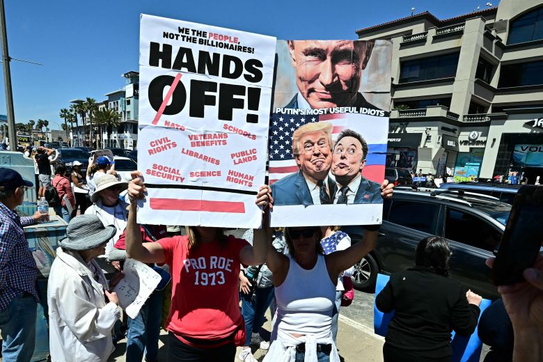 5일 미국 캘리포니아 헌팅턴비치에서 열린 '손을 떼라(Hands Off)' 반(反)트럼프 시위에서 참가자들이 트럼프와 머스크의 사진을 든 채 행진하고 있다. /AFP 연합뉴스