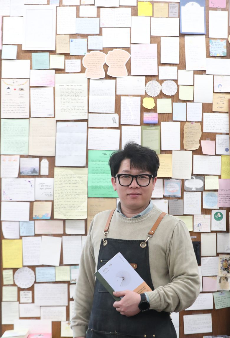 2025년 3월 27일 오전 부산 수영구에 위치한 서점 '주책공사'의 이성갑 대표가 독립출판물 작가들이 써놓은 감사 쪽지 앞에서 포즈를 취했다./김동환 기자