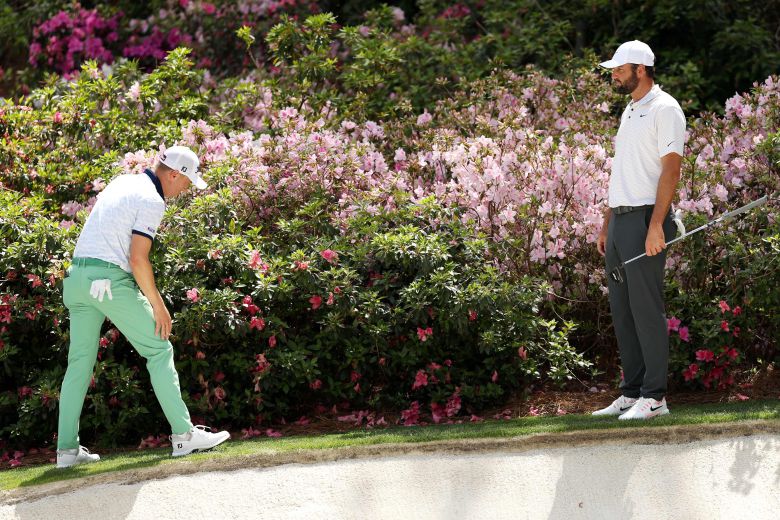 저스틴 토머스(왼쪽)가 2025 마스터스 1라운드 13번 홀에서 샷 실수를 하고 나서 그린 주변 꽃밭에서 동반 플레이어 스코티 셰플러와 함께 공을 찾고 있다. /AFP 연합뉴스