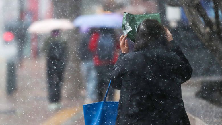 강풍을 동반한 눈비가 갑작스럽게 내린 13일 오후 서울 중구 덕수궁 인근에서 시민들이 발걸음을 재촉하고 있다. /박성원 기자