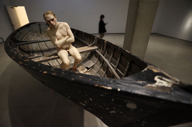 '배에 탄 남자'(2002)가 전시된 모습. 팔을 모아 벗은 몸을 간신히 가린 남자가 보트의 뱃머리에 앉아 무언가를 의심하는 듯한 눈길을 보내고 있다. 159 × 138 × 429cm. 개인 소장. /연합뉴스