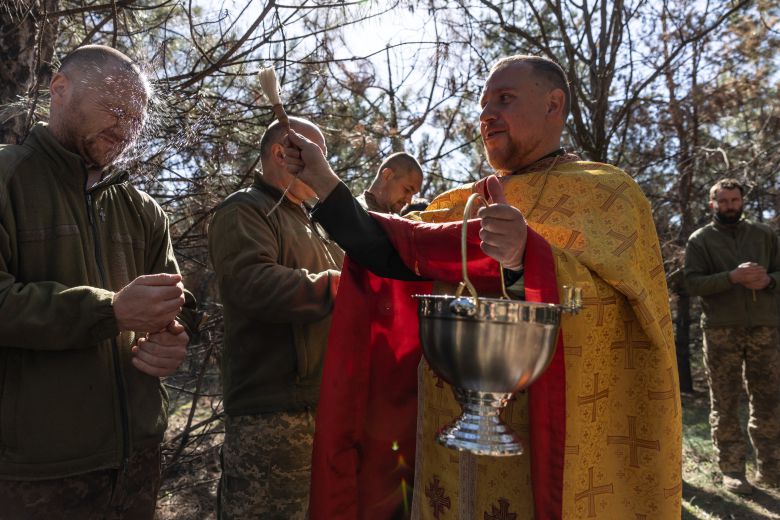 지난 20일 부활절을 맞은 우크라이나 드니프로 지역, 군 목사가 군인들에게 성수(聖水)를 뿌리고 있다. /로이터 연합뉴스