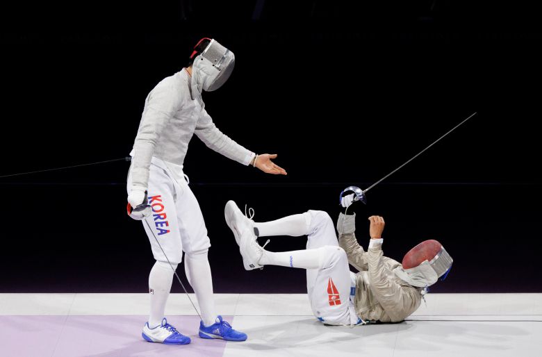 오상욱(왼쪽)이 파리 올림픽 남자 펜싱 사브르 개인전 결승에서 페르자니가 경기 도중 넘어지자 손을 건네 일으켜 주는 모습. / 연합뉴스