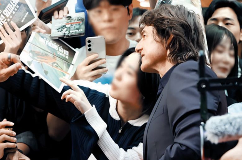 지난 8일 톰 크루즈가 서울 롯데월드에서 열린 레드카펫 행사에서 팬과 함께 사진을 찍고 있다. /연합뉴스