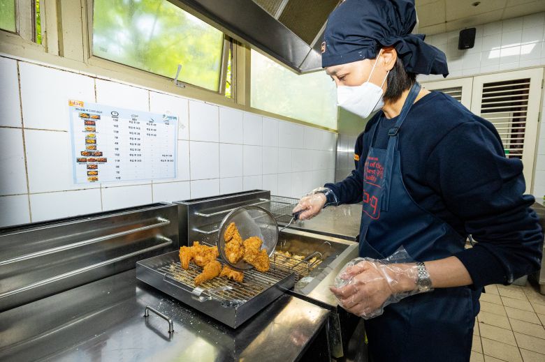 정시행 기자가 튀겨진 닭을 기름에서 건져내고 있다. 칼집을 잘못 내 이미 망친 치킨. 상품이 될 수 없다. /이건송 영상미디어 기자