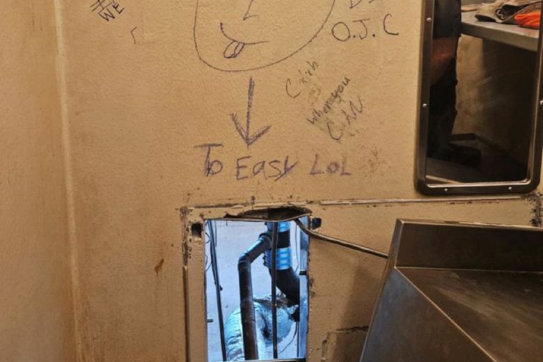 수감자들이 탈출한 화장실 변기 뒷편 구멍과 벽에 적혀있는 '너무 쉽네'라는 조롱성 낙서. /AP 연합뉴스