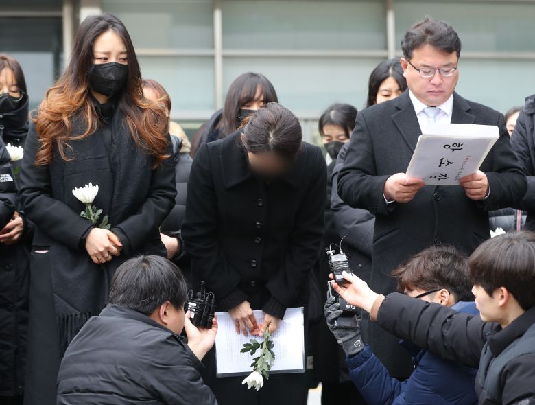 유명 웹툰 작가 주호민씨의 자폐 아들을 학대한 혐의로 1심에서 벌금 200만원 선고유예를 받은 특수교사 A씨(가운데). 사진은 지난해 2월 6일 오전 경기 수원시 영통구 수원지방법원에서 기자회견을 마치고 인사를 하고 있는 모습. /뉴스1