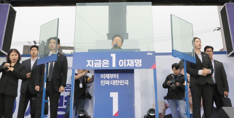 Democratic Party presidential candidate Lee Jae-myung appeals to voters from behind bulletproof glass during a campaign rally near Hongik University in Seoul's Mapo district on May 19. /Nam Gang-ho