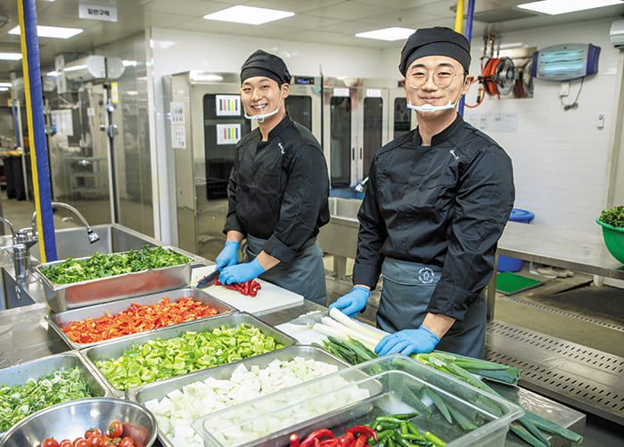 지난달 15일 경기 용인시 현대그린푸드 본사에서 고졸 사원 이종호(왼쪽), 강희원씨가 식자재를 손질하다가 포즈를 취했다. /조인원 기자