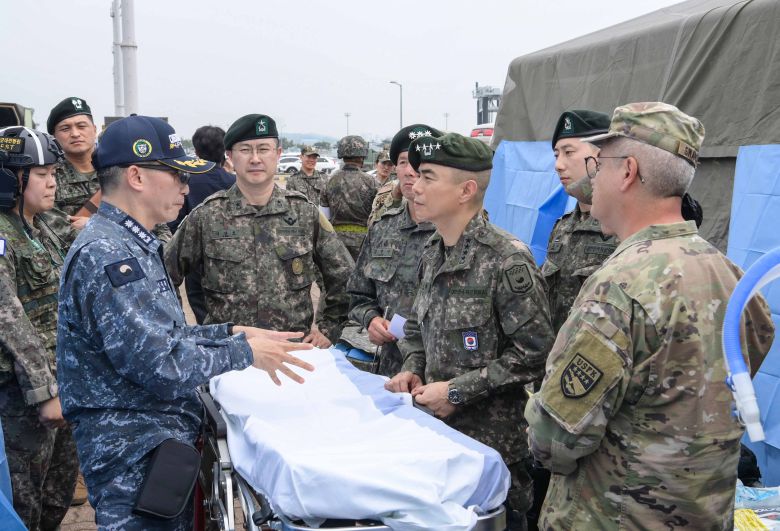 22일 평택항에서 진행된 연합·합동 의무지원훈련 현장에서 이국종(왼쪽 셋째) 국군 대전병원 병원장이 강신철(맞은편 4성 베레모를 쓴 이) 한미연합군사령부 부사령관에게 전방전개외과팀 운영에 관해 설명하고 있다. /한미연합사