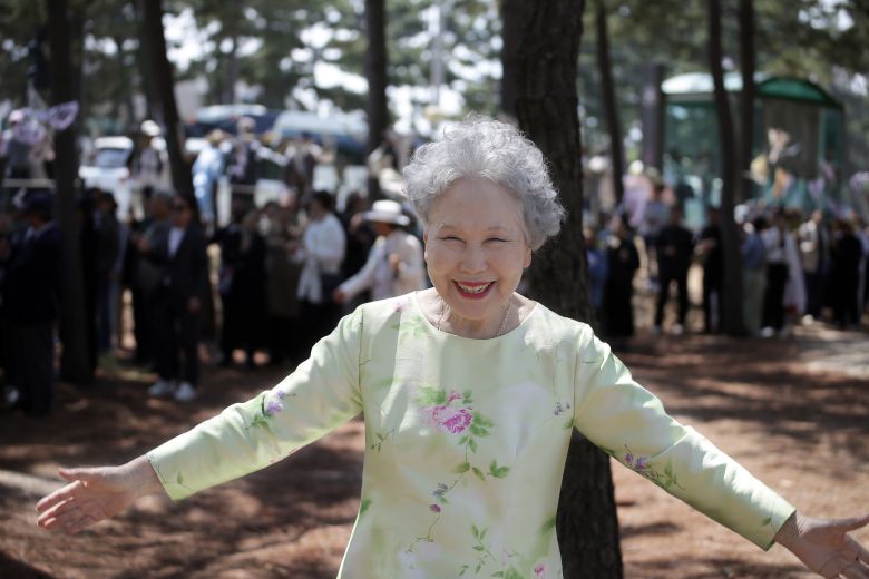 25일 강릉 순포해변 영화 '청명과 곡우 사이' 하이라이트 장면 촬영 현장. 박정자가 이 영화의 주제음악 제목 "환한 웃음으로"를 말하며 활짝 웃었다. 그의 뒤로 전날부터 함께 해준 '조문객' 150여명이 출연작 제목이 적힌 만장을 들고 서 있다. /강릉=이태훈 기자