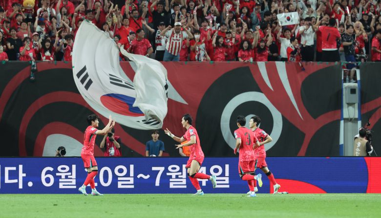 한국 축구 대표팀이 10일 서울월드컵경기장에서 열린 쿠웨이트와의 2026 북중미 월드컵 아시아 3차 예선 B조 10차전에서 4대0 대승을 거뒀다. 세 번째 골을 넣은 오현규(왼쪽에서 둘째)가 동료들과 함께 기뻐하는 가운데 관중석 커다란 태극기가 펄럭이고 있다. /연합뉴스