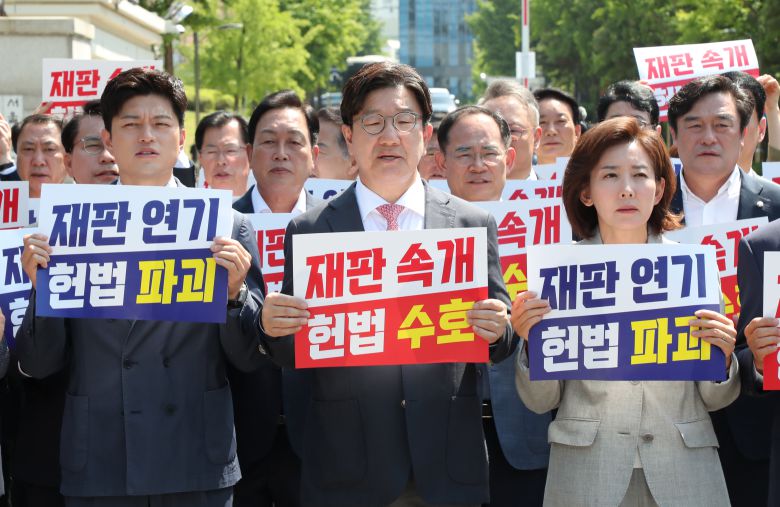 국민의힘 김용태 비상대책위원장과 권성동 원내대표 등 참석의원들이 11일 이재명 대통령의 공직선거법 위반 사건의 파기환송심을 사실상 무기한 연기한 서울고등법원 앞에서 열린 현장 의원총회에서 구호를 외치고 있다. /남강호 기자