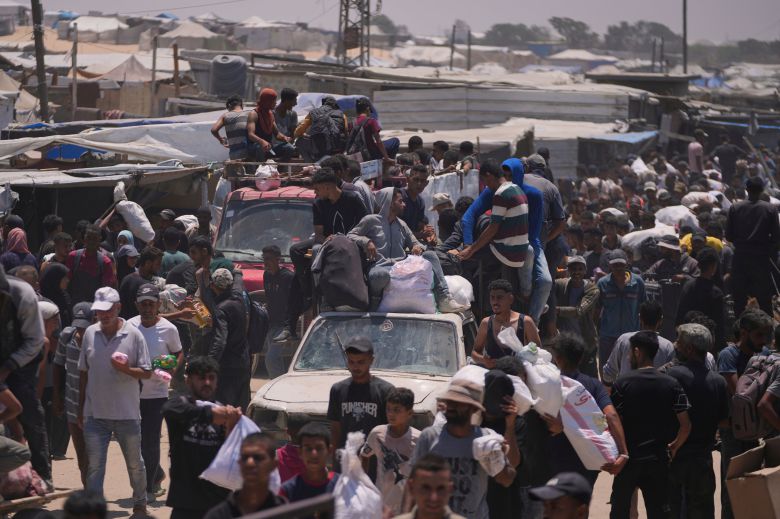 12일 음식과 구호 물품이 들어있는 가방을 챙기고 있는 팔레스타인 가자 지역 주민들. /AP 연합뉴스