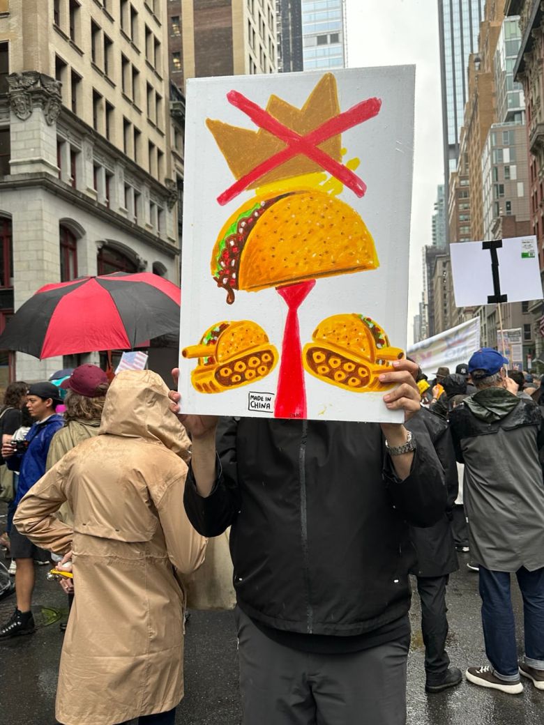 14일 뉴욕에서 열린 시위에 한 시민이 타코 그림을 들고 나왔다. 최근 도널드 트럼프 대통령의 정책을 ‘타코(트럼프는 항상 겁먹고 도망친다·Trump Always Chickens Out)’라고 비꼰 것을 나타냈다.