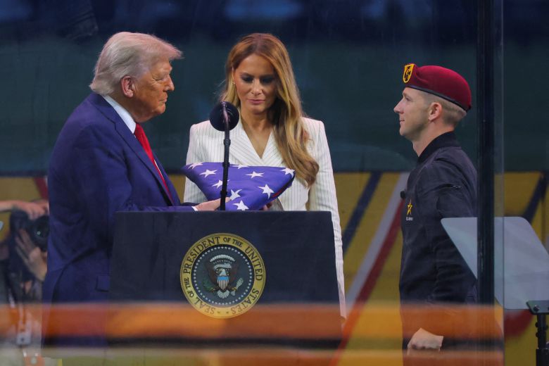 도널드 트럼프 미국 대통령이 지난 14일 미국 워싱턴DC에서 열린 육군 창설 250주년 기념 퍼레이드에서 미 육군 골든나이츠 낙하산 팀원으로부터 성조기를 받고 있다. /로이터 연합뉴스