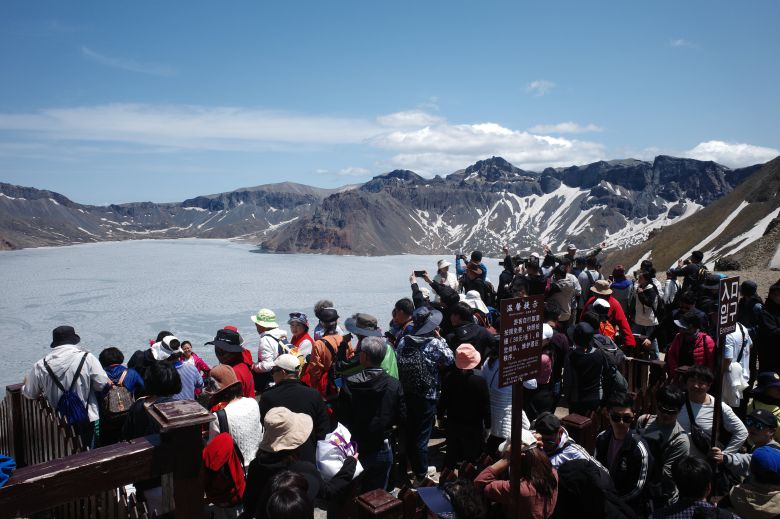 지난 12일 백두산 정상(서파)에 오른 수많은 관광객들이 백두산 천지를 구경하는 모습. /박성원 기자
