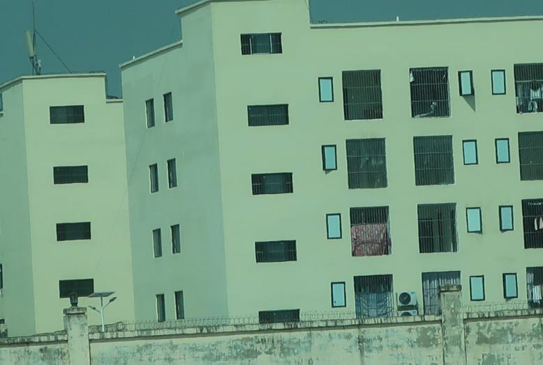 캄보디아의 한 사기 작업장 창문에 쇠창살이 쳐져 있고, 담에는 철조망이 둘러진 모습. /국제앰네스티