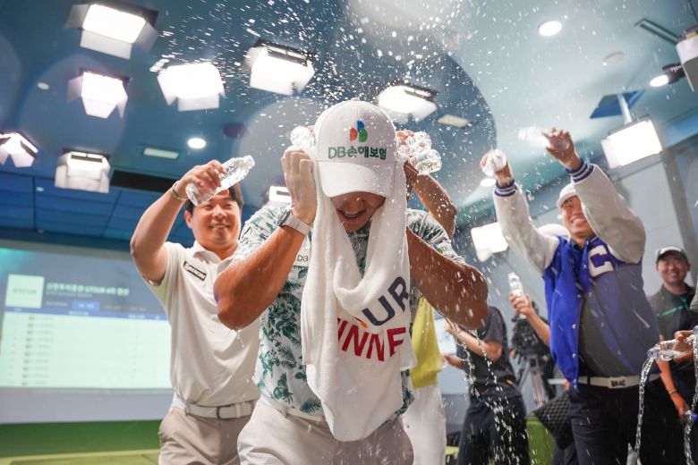 스크린 골프장에서 펼쳐지는 '2025 신한투자증권 G투어' 4차 대회 우승을 차지한 김홍택을 축하하는 선수들. /골프존