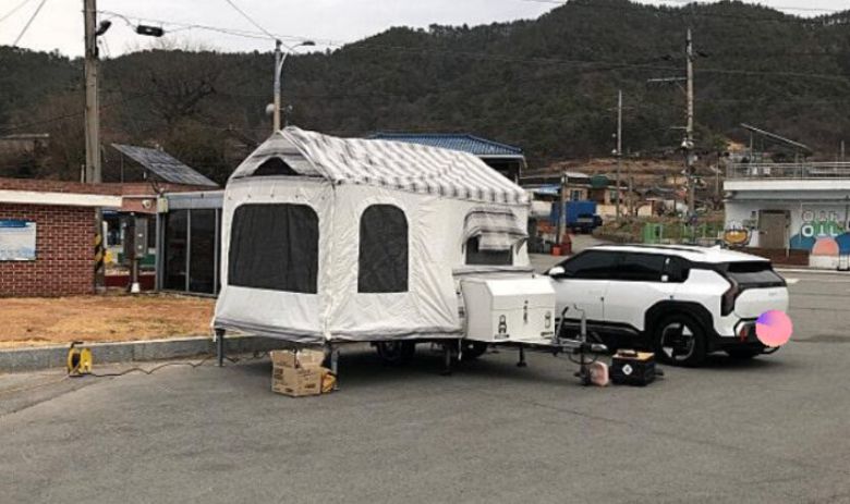 전선이 인근에 세워진 캠핑 트레일러와 차량까지 이어진 모습./보배드림