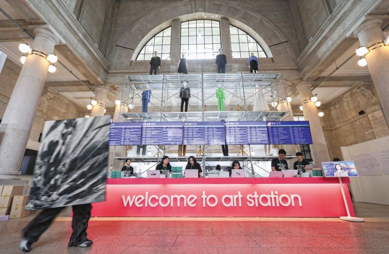 ‘2025 아시아프’가 열리는 옛 서울역사 로비가 거대한 플랫폼으로 변신했다. 열차 출발을 알리는 시간표엔 작가 이름과 작품명이 적혔다. 올해 크리에이티브 디렉터로 참여한 이완 작가의 설치 작품 ‘표준시’다. /고운호 기자