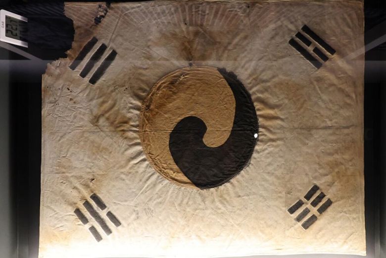 대한민국역사박물관 특별전에 전시된 1900년 파리 만국박람회 출품 추정 태극기(위쪽)와 덕수궁 돈덕전 특별전에 전시된 진관사 태극기./조인원·장경식 기자