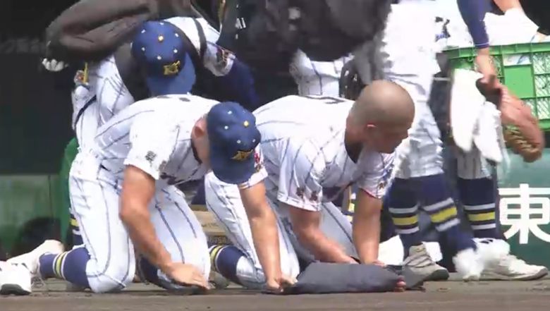 일본 군마현 겐다이타카사키고 야구부 선수들이 13일 전국고교야구선수권대회에서 재일 한국계 교토국제고에 패배한 뒤 한신 고시엔 구장의 흙을 퍼담고 있다.