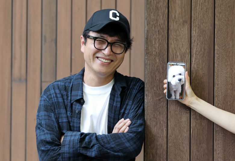 소설가 이기호와 그의 반려견 이시봉(오른쪽 휴대전화 속 사진). 소설 속 이시봉과는 다른 개지만, 소설의 결말부를 바꿀 정도로 지대한 영향을 미쳤다. “원래 구상할 때 이시봉은 죽었는데, 그 부분에서 1년 동안 한 문장도 못 쓰겠더라고요.” /박성원 기자