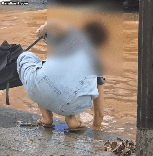 지난 14일 경기 일산에서 한 여성이 침수된 도로를 막고 있는 쓰레기를 제거하고 있다./인스타그램