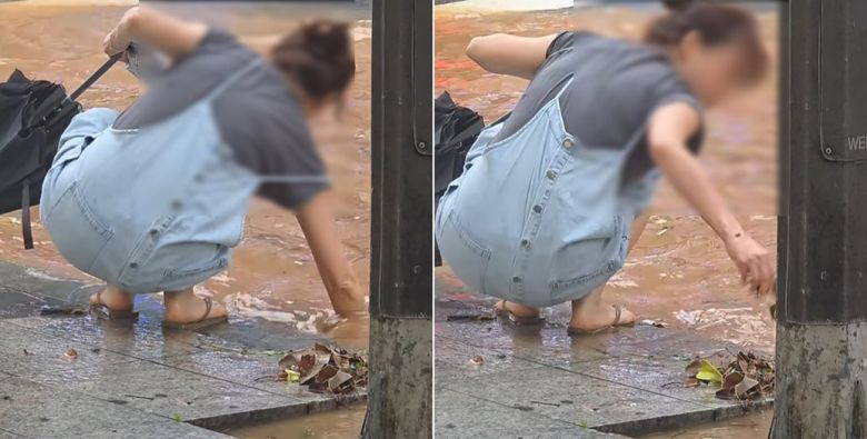 지난 14일 경기 일산에서 한 여성이 침수된 도로를 막고 있는 쓰레기를 제거하고 있다./인스타그램