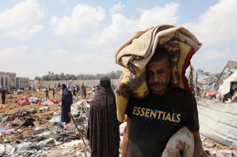 21일 이스라엘의 공습을 받은 가자지구 중부 데이르알발라의 한 난민캠프에서 한 남성이 허탈한 표정으로 소지품을 챙겨 떠나고 있다./AFP 연합뉴스