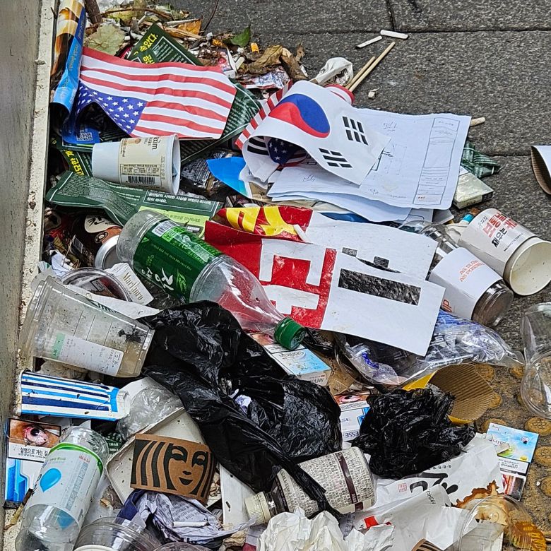 지난 17일 서울 종로구 세종대로 뒤편에 버려진 태극기. 소주병, 성조기, 시위 플래카드 등과 함께 나뒹굴고 있다. /안태민 기자