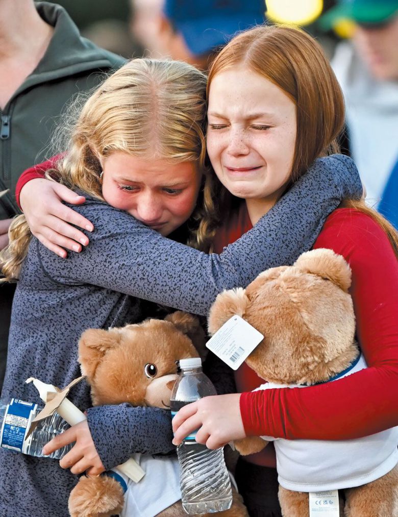 미국 미네소타주 미니애폴리스의 가톨릭계 학교에서 총기 난사 사건이 발생한 27일, 희생자들을 추모하기 위해 열린 촛불 기도회에서 두 어린이가 서로 감싸안고 위로하고 있다. 미사 중이던 어린이 두 명이 사망한 이 사건 이후 미니애폴리스 곳곳에서 추모 집회와 기도회가 열렸다. /EPA 연합뉴스