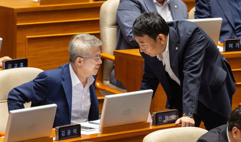 검찰정상화특위위원장을 맡은 더불어민주당 민형배 의원(왼쪽)과 민주당 법사위 간사인 김용민 의원이 지난 25일 국회에서 열린 본회의에서 대화하고 있다./연합뉴스