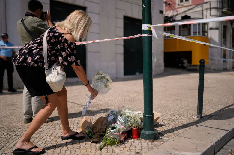 4일(현지시각) 포르투갈 리스본에 관광용 케이블전차(푸니쿨라) 탈선추락 사고 현장 주변에 한 시민이 추모의 꽃을 놓고 있다./AP 연합뉴스