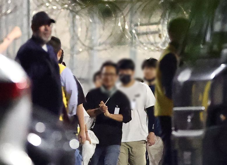 美 구금 시설서 나오는 한국인들 - 미국 조지아주 포크스턴의 이민세관단속국(ICE) 시설에 억류돼 있던 한국인들이 11일 새벽 밖으로 나오고 있다. 일행 중 일부가 안도한 듯 밝은 표정을 짓고 있다. 앞서 지난 4일 ICE 단속으로 조지아주 엘러벨의 현대차·LG에너지솔루션 합작 공장에서 한국인 317명을 포함해 총 475명이 체포됐다. 이들은 애틀랜타 하츠필드잭슨 공항에 도착해 있던 전세기 편으로 귀국 길에 올랐다. /연합뉴스