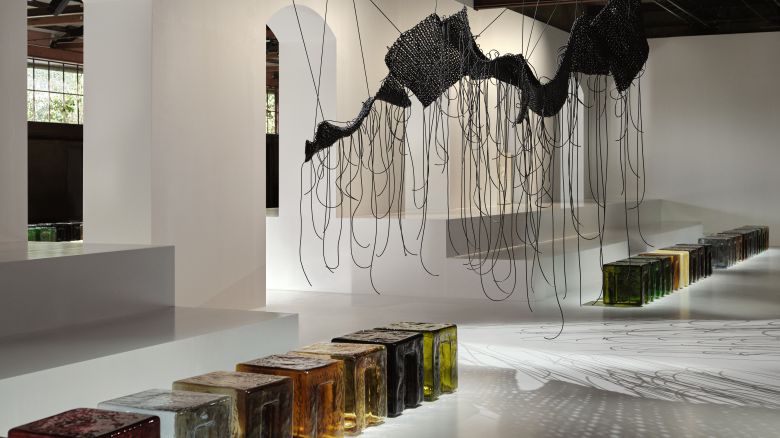 보테가 베네타 2026 여름 쇼 현장 내부는 디자인 브랜드 6:AM과 협업한 맞춤형 무라노 유리 스툴 시리즈가 좌석으로 마련됐고, 천장 곳곳에는 현대 미술가 이광호의 작품이 배치돼 있었다. /보테가 베네타