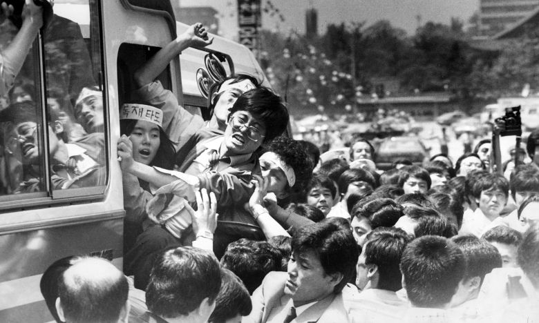 1985년 5월 서울 미국문화원 점거를 주도했던 함운경(가운데 안경쓴 이)이 72시간 만에 농성을 끝낸 뒤 경찰 버스에 오르며 구호를 외치고 있다. 사건 직후 점거 참여 73명 중 함운경(서울대),신정훈(고려대),이정훈(고려대) 등 25명이 구속됐고, 김민석(서울대),허인회(고려대),박선원(연세대),고진화(성균관대) 등 10여 명은 배후 명목으로 수배됐다. /조선일보 DB